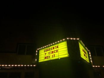 Low angle view of illuminated sign at night