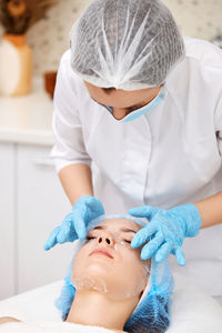 High angle view of doctor examining patient at home