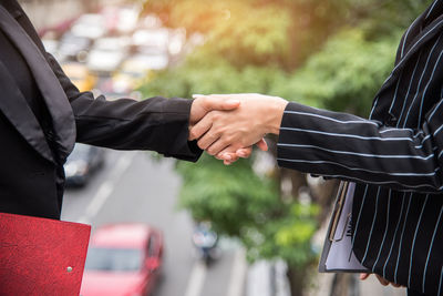 Midsection of business people shaking hands