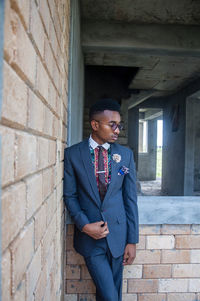 Young man standing against wall