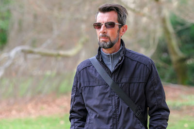 Midsection of man wearing sunglasses standing outdoors