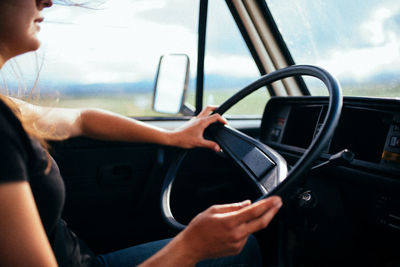 Midsection of woman driving car