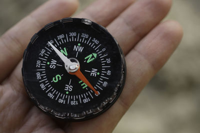 Close-up of person holding navigational compass outdoors