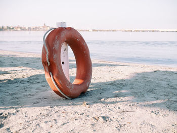 Life belt at beach against clear sky