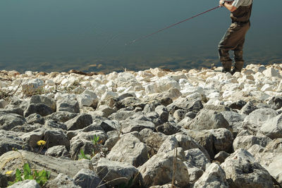 Low section of man fishing in lake