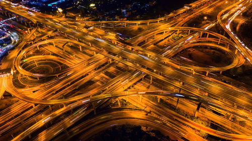 Aerial view of light trails on bridge in city at night