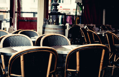 Empty tables and chairs at sidewalk cafe