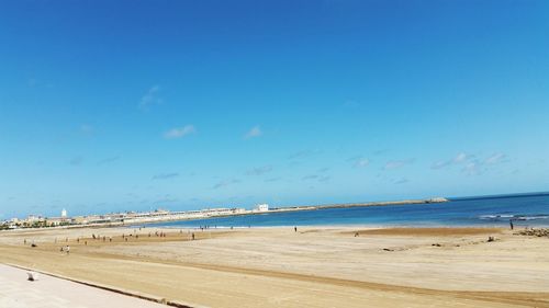 Scenic view of beach against blue sky