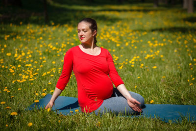 Portrait of young woman sitting on field