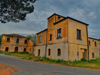 Old building by road against sky