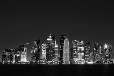 Illuminated buildings in city against sky at night