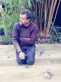 Young man looking away while sitting in yard