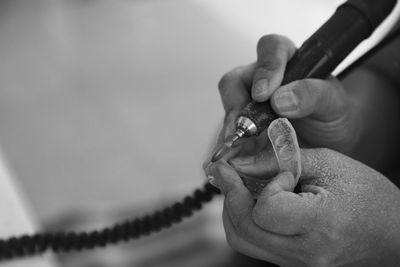 Cropped hands of dentist holding braces