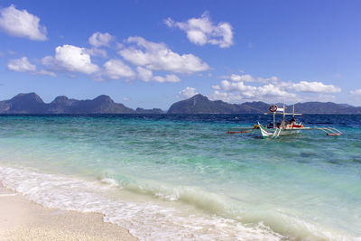 View of calm beach against blue sky