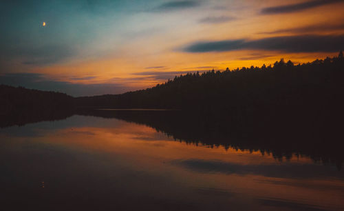Scenic view of lake against sky at sunset