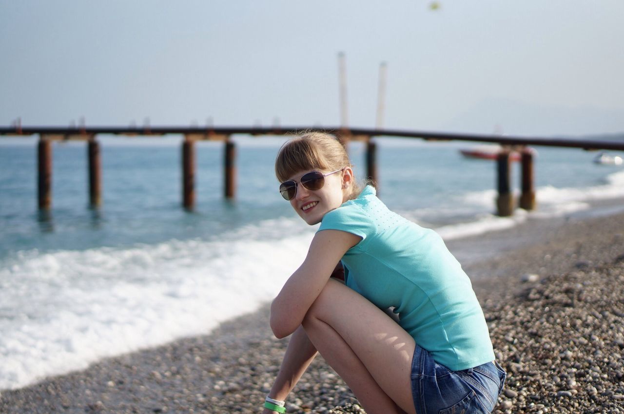 water, beach, focus on foreground, lifestyles, leisure activity, casual clothing, person, sea, shore, childhood, clear sky, elementary age, standing, sand, boys, railing, looking at camera, portrait