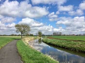Road amidst field against sky