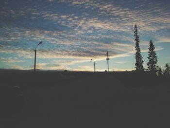 Silhouette landscape against cloudy sky