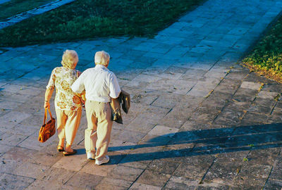 Rear view of senior couple walking on footpath