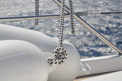 Close-up of rope tied on metal against sea