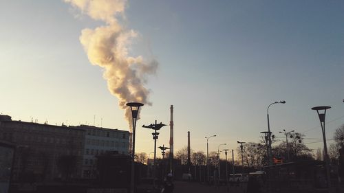 Smoke emitting from factory against sky