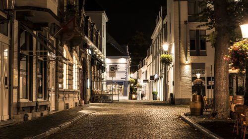 Street amidst buildings in city at night