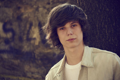 Portrait of man against tree trunk