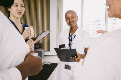 Multiracial healthcare team discussing while standing at hospital