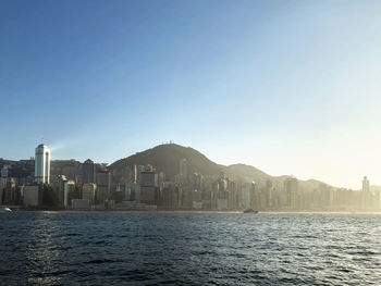 View of buildings by sea against clear sky