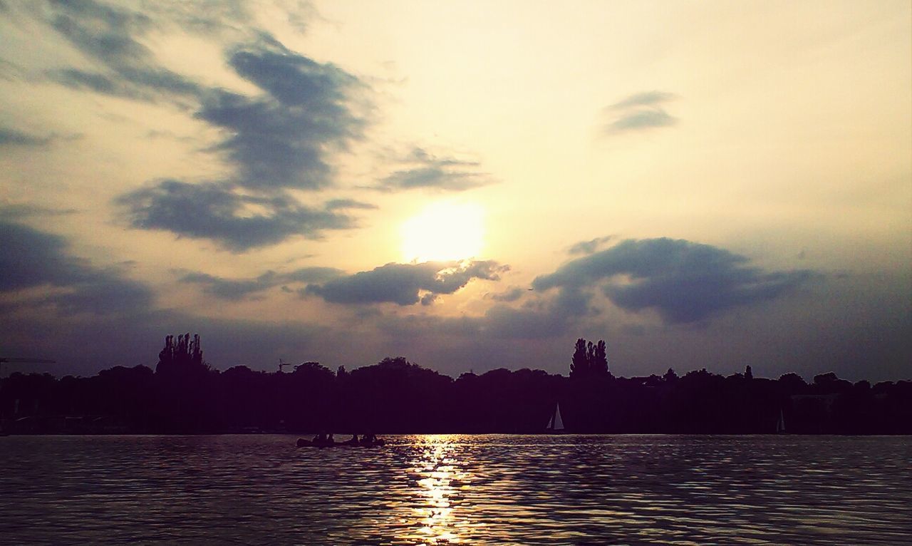 silhouette, water, sunset, waterfront, architecture, building exterior, sky, built structure, reflection, river, cloud - sky, sun, scenics, city, beauty in nature, rippled, nature, tranquility, cloud, lake