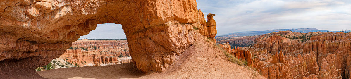 View of rock formation against cloudy sky