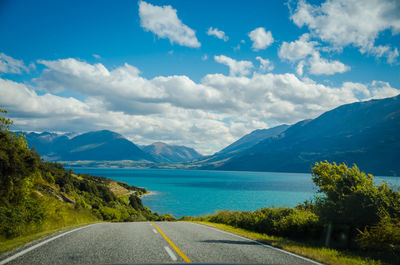 Road by mountains against sky