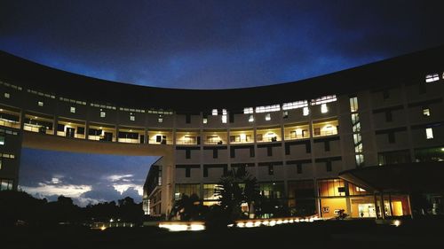 Low angle view of illuminated city against sky at night