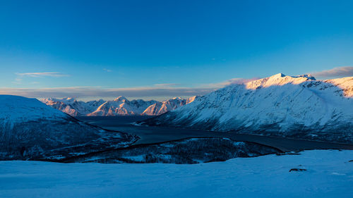 Scenic view of snowcapped mountains against blue sky