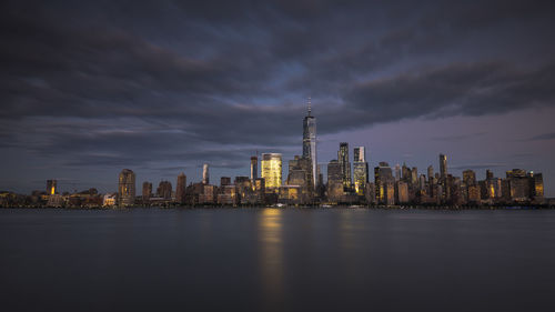 Illuminated buildings in city against sky