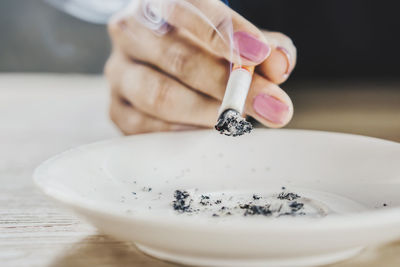 Close-up of cropped hand holding cigarette