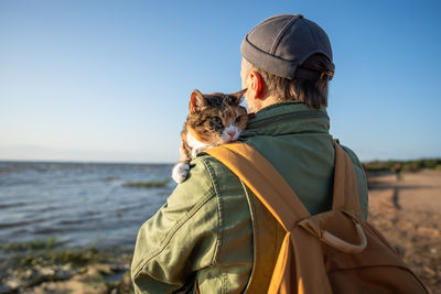 Rear view of woman sitting on beach