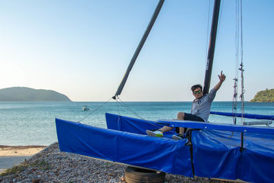 Sailboats in sea against clear blue sky