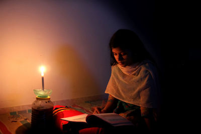 Girl looking away while sitting on table