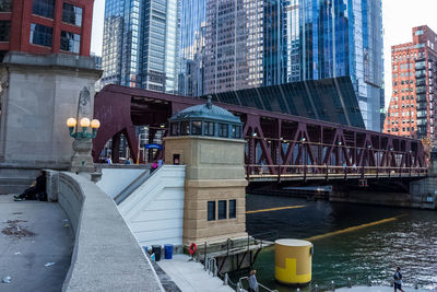 Bridge over river by buildings in city