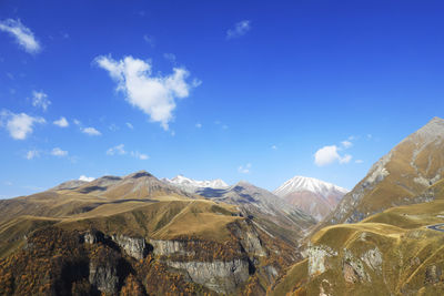 Panoramic view of snowcapped mountains against blue sky