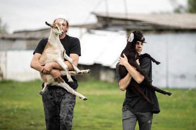 Local agriculture, farmer's day 12 october. a man with a goat in his arms, natural products.