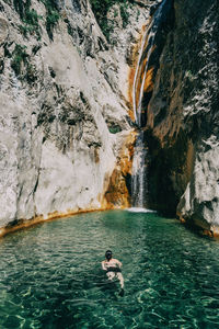Girl in the water in a waterfall in sadernes, catalonia