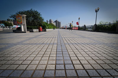 Surface level of footpath by buildings against sky