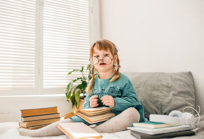 Girl sitting with books at home