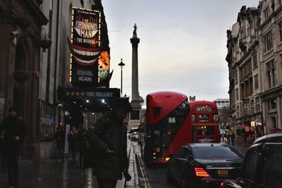 People on street amidst buildings in city