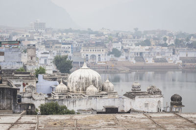 View of pushkar town by lake during foggy weather