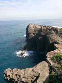 Scenic view of rock formation by sea against sky