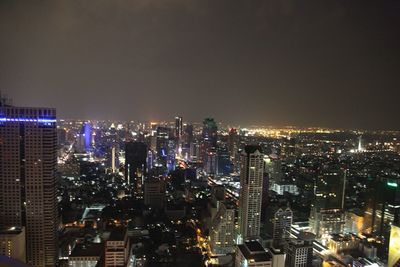 High angle view of illuminated buildings against sky at night