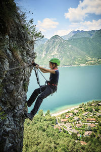 Girl climbing mountain with lake idro in background